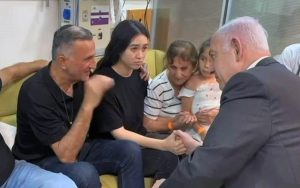 El primer ministro, Benjamin Netanyahu, con la rehén rescatada Noa Argamani, su padre Yaakov y su familia en el Centro Médico Sheba en Ramat Gan, el 8 de junio de 2024. (GPO)